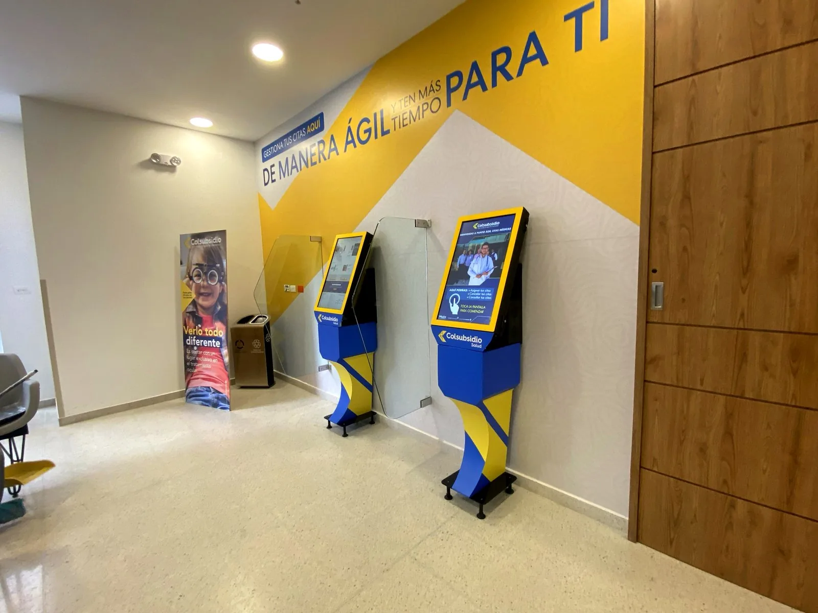 Dos kioscos de piso para autogestión instalados en la sala de espera de una sede de salud en Colombia